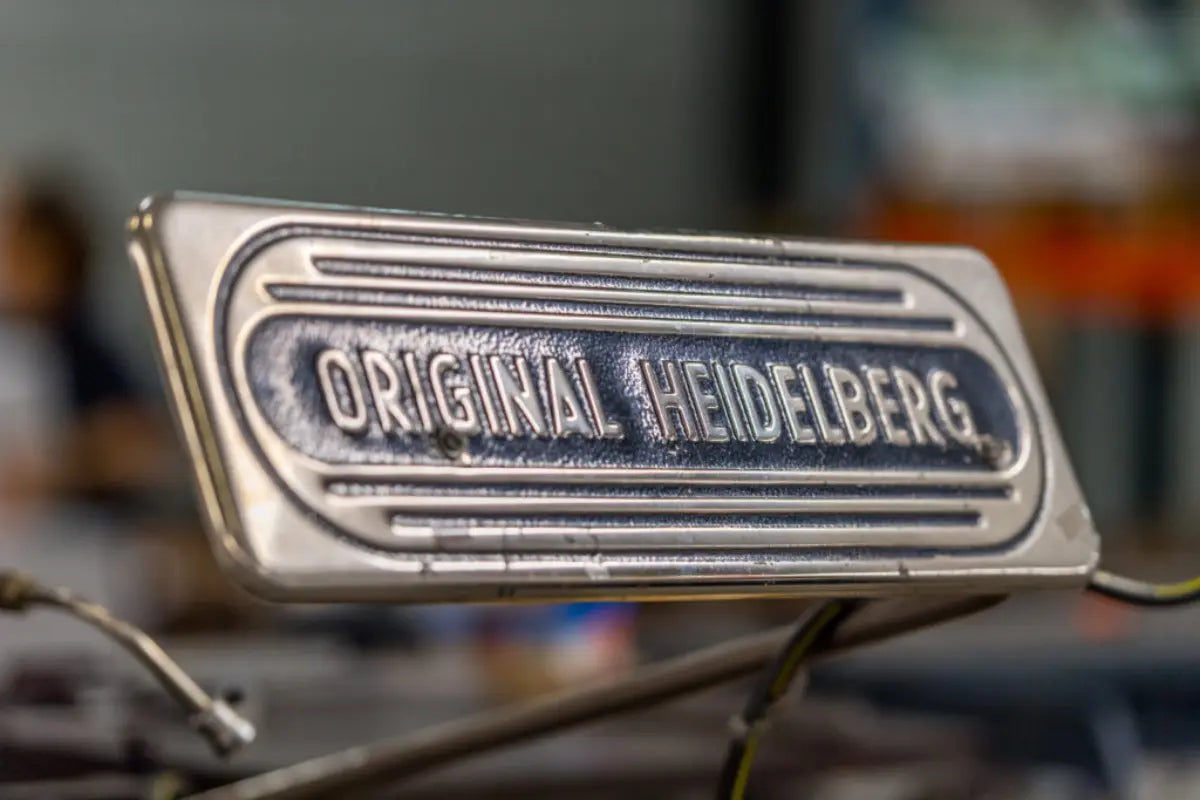 Plaque métallique Original Heidelberg sur une presse typographique utilisée par La Bobine Française. Machine emblématique de l'impression, reconnue pour sa précision et sa robustesse.